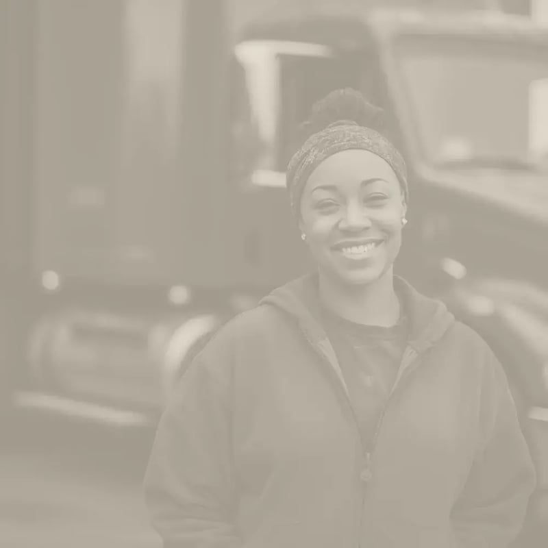Female truck driver poses in front of her semi truck